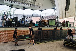 More details Road crews (roadies) working on the stage construction for a concert in an outdoor amphitheater in Portsmouth, Virginia. For more music news and resources follow aeonar grey