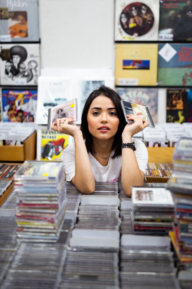 Gorgeous woman holding compact discs. Follow Aeonar Grey.